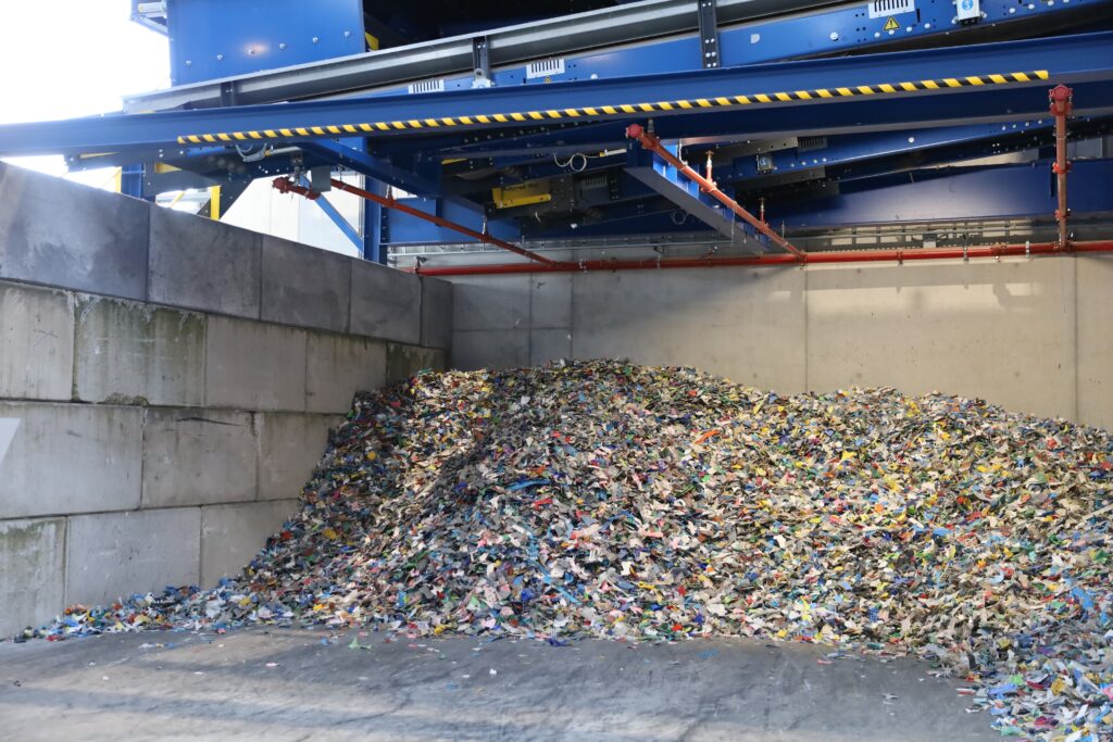 Geshredderd, gewassen en gesorteerd kunststof in een bunker bij een kunststofrecycler.